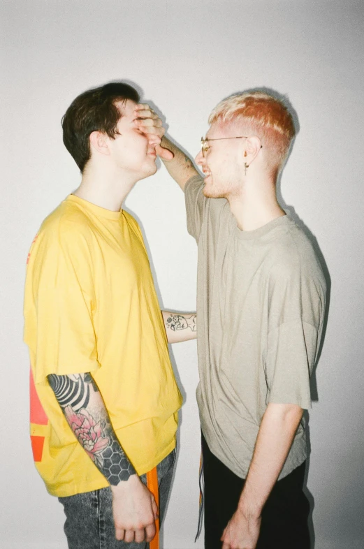 a couple of young men standing next to each other, trending on pexels, aestheticism, albino hair, yellowed, high detal