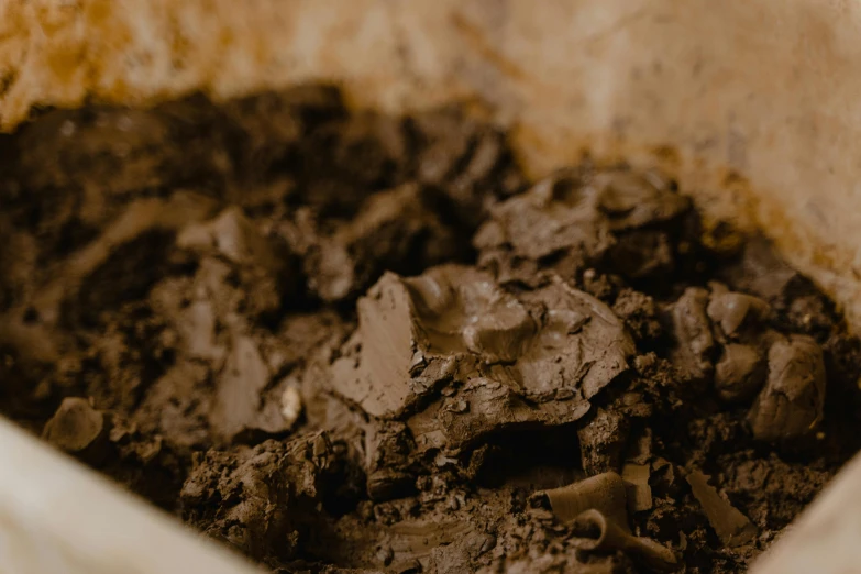 a close up of a bowl of dirt, trending on pexels, process art, background image, dark chocolate hair colour, cake, grey