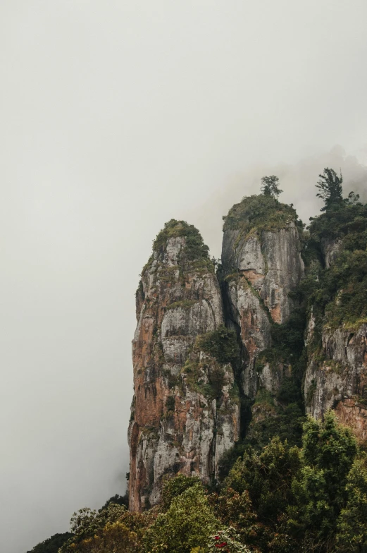 a group of people standing on top of a mountain, tall stone spires, south african coast, subtle fog, monserrat gudiol