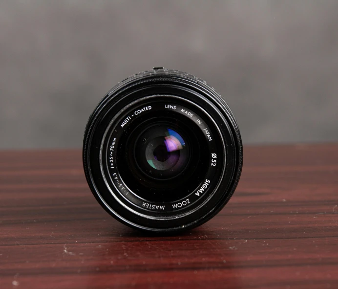 a camera lens sitting on top of a wooden table, by Mathias Kollros, unsplash, photorealism, 8 0 s camera, miniature product photo, detailed photograph high quality, highly detailed photorealistic