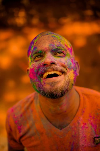 a man with paint all over his face, pexels contest winner, color field, a still of a happy, orange hue, religious, mdma