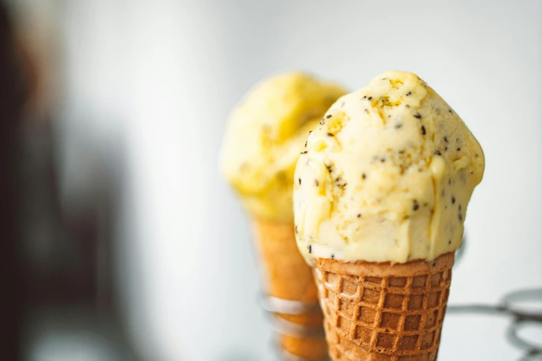a couple of ice cream cones sitting on top of a table, yellow and charcoal, manuka, epicurious, thumbnail