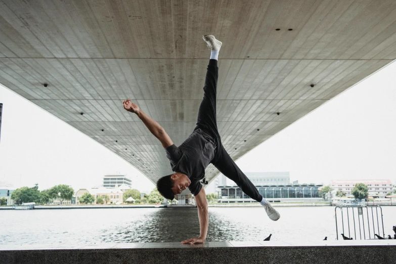 a man doing a handstand under a bridge, by Niko Henrichon, arabesque, avatar image, ross tan, profile image, thumbnail