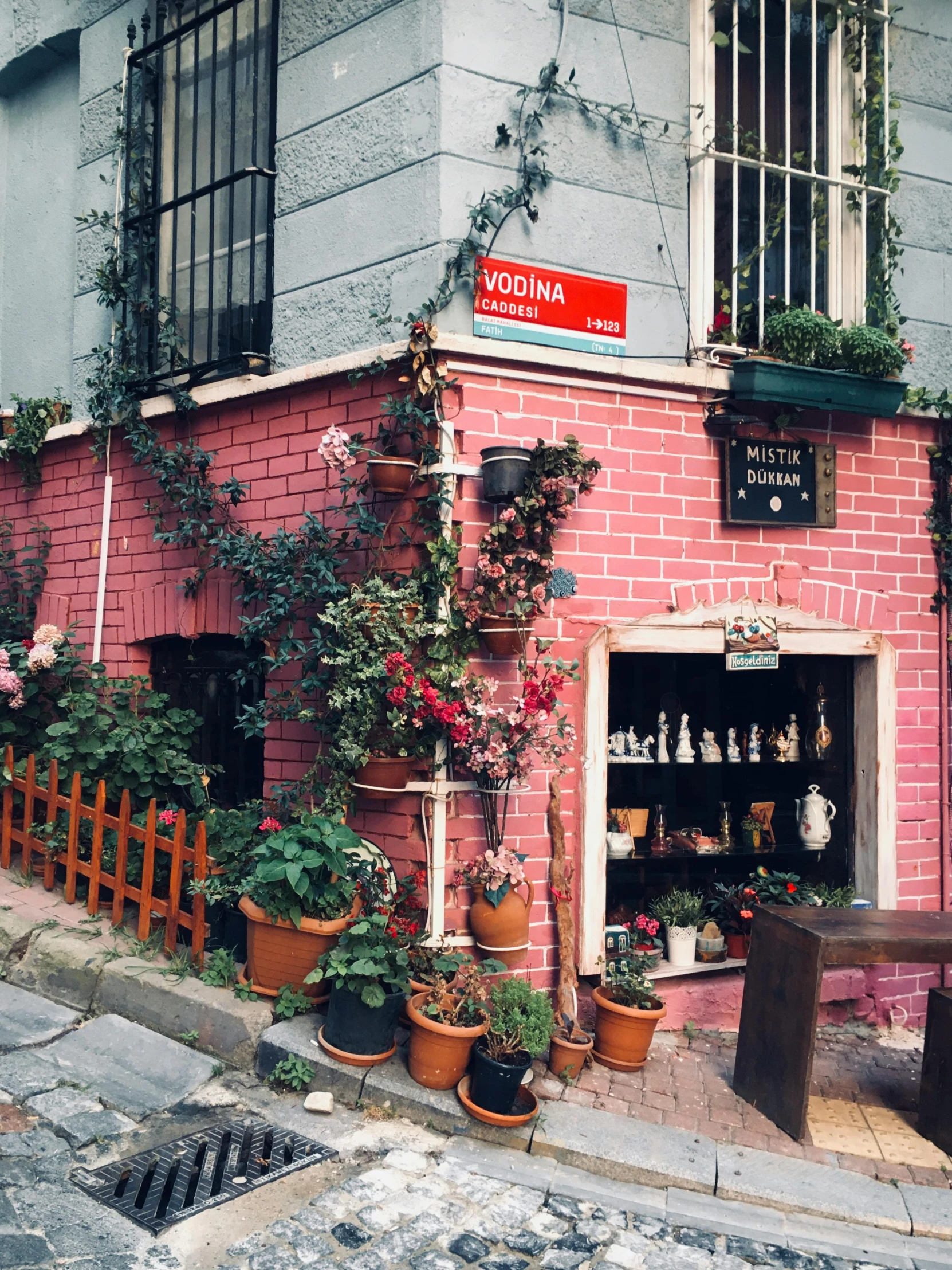 a red brick building sitting on the side of a street, a photo, by Lucia Peka, art nouveau, flower shop scene, istanbul, ((pink)), photo for vogue