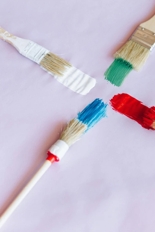 a group of paint brushes sitting on top of a table, pink and red color scheme, brand colours are green and blue, white paint, profile image