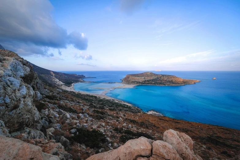 a large body of water sitting on top of a rocky hillside, by Simon Marmion, pexels contest winner, greek, square, lagoon, amanda clarke