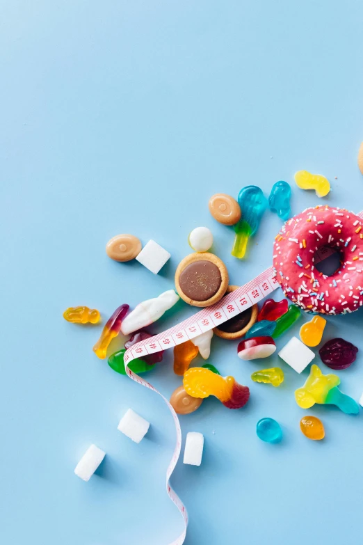 a donut covered in sprinkles next to a measuring tape, a picture, trending on pexels, hurufiyya, made of candy and lollypops, pills, square, biological