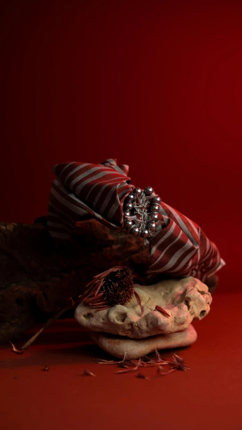 a couple of baseball mitts sitting on top of a table, by Gwen Barnard, surrealism, dark red background, cloth head wrap, bejewelled and encrusted royalty, red and white stripes