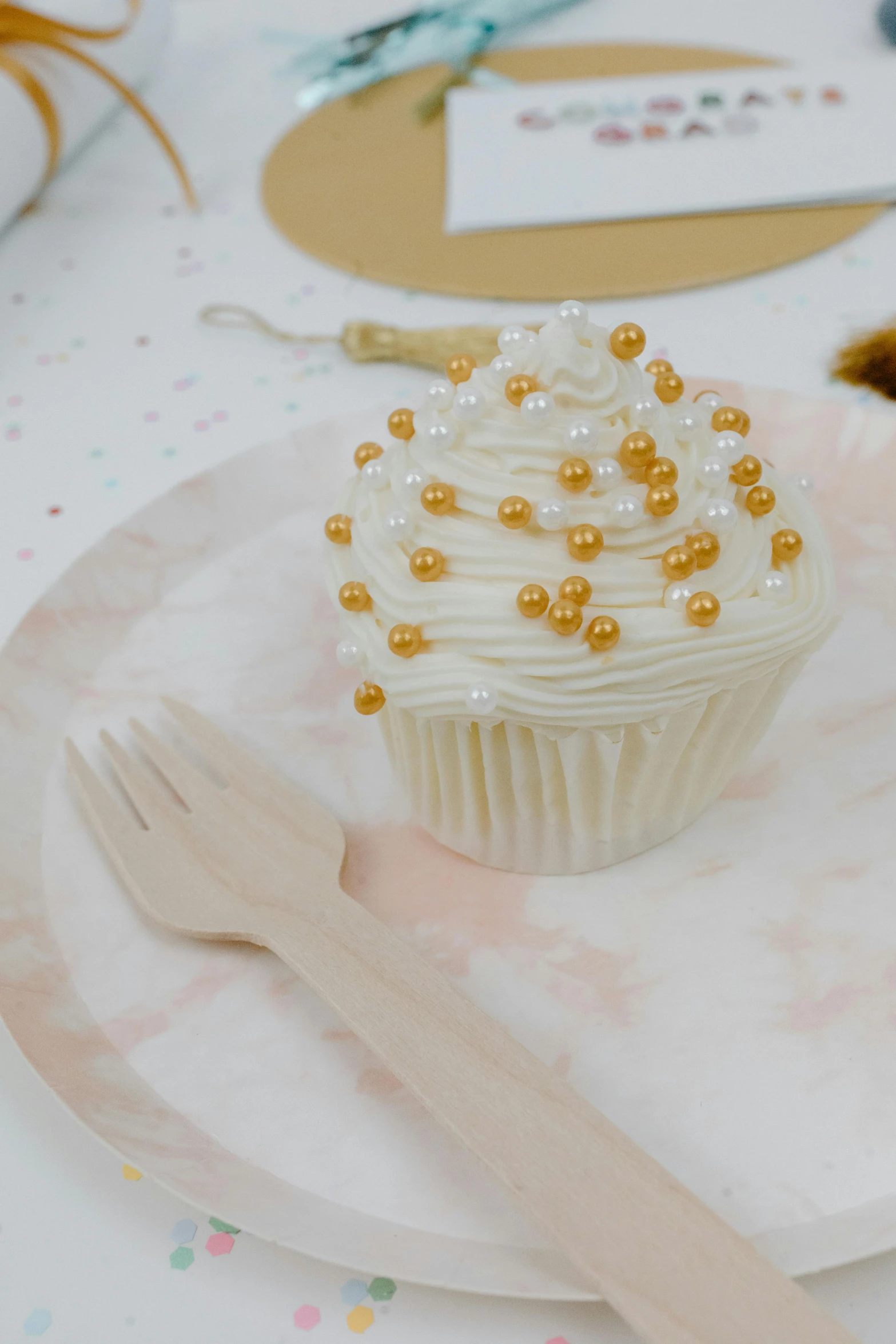 a cupcake sitting on top of a white plate, gold and pearls, fork fork, white holographic plastic, detailed product image