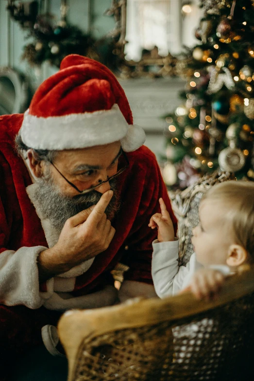 a man sitting in a chair next to a baby, a photo, pexels, santa's workshop, profile image, smelling good, texture