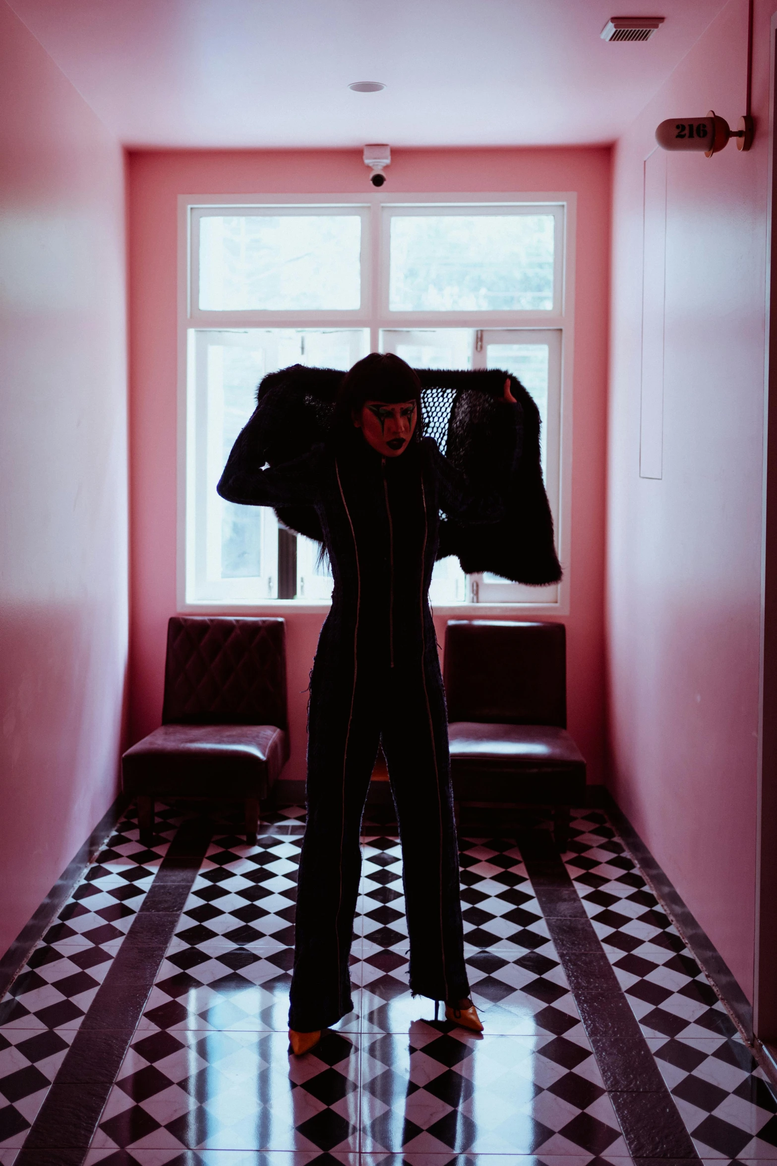 a man that is standing in a hallway, an album cover, inspired by Elsa Bleda, pexels contest winner, bauhaus, fullbodysuit, goth woman, hotel room, tracksuit