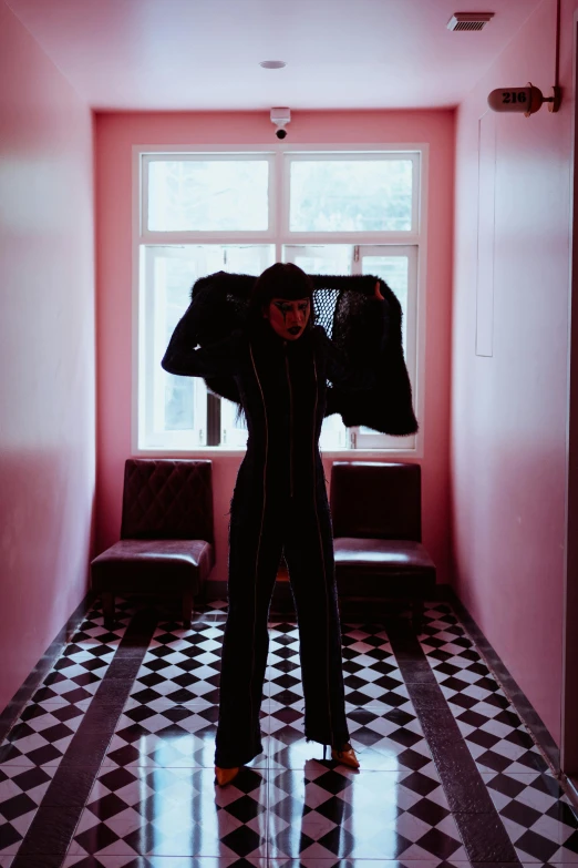 a man that is standing in a hallway, an album cover, inspired by Elsa Bleda, pexels contest winner, bauhaus, fullbodysuit, goth woman, hotel room, tracksuit