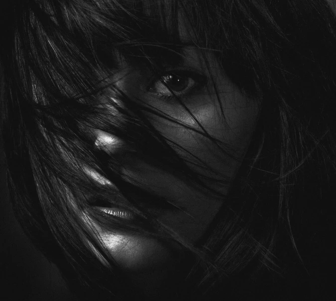 a black and white photo of a woman's face, trending on cgsociety, hurufiyya, with full bangs, alternate album cover, hiding, windswept