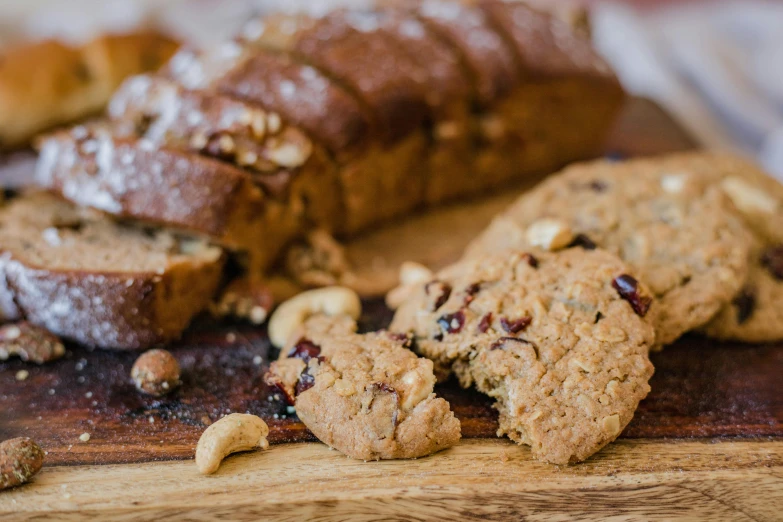 a loaf of bread sitting on top of a wooden cutting board, by Joe Bowler, pexels, cookies, having a snack, nuttavut baiphowongse, 🎀 🗡 🍓 🧚