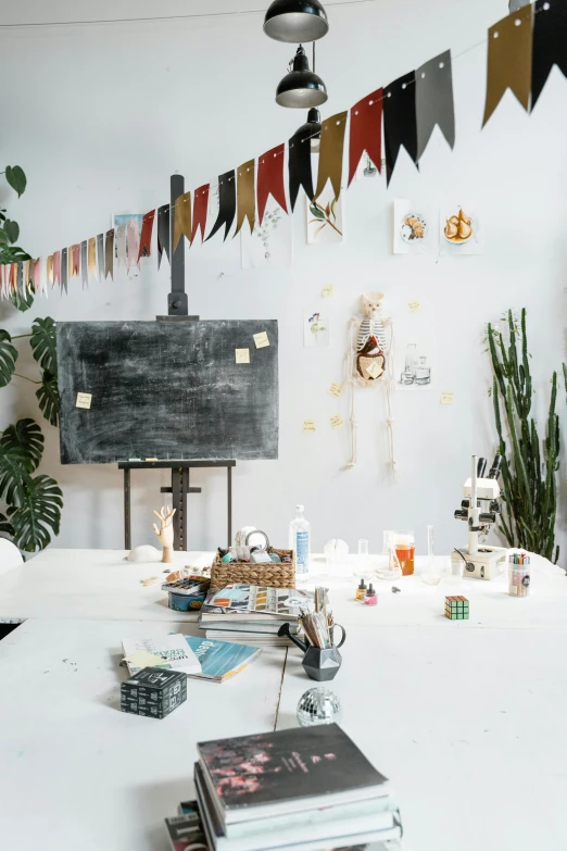 a white table topped with lots of books, art school, decorations, adafruit, studio product shot