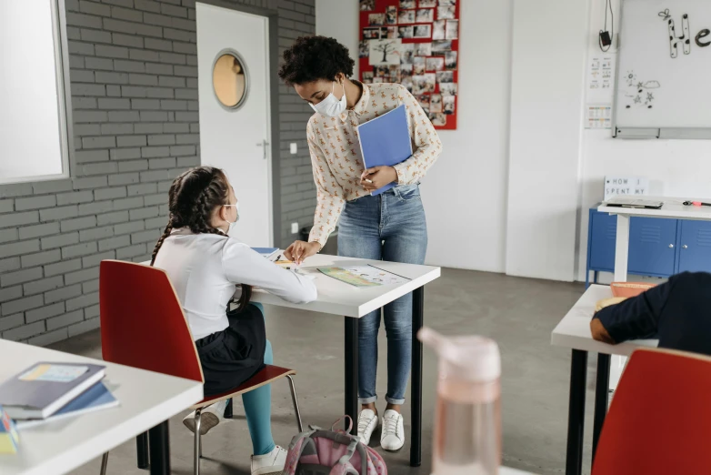 a group of children sitting at desks in a classroom, trending on pexels, woman holding another woman, profile image, thumbnail, standing on a desk