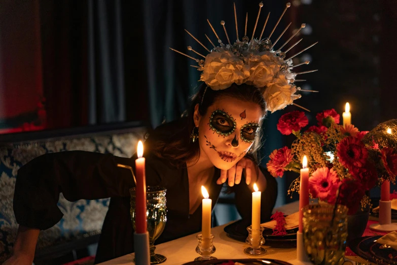 a woman sitting at a table with candles in front of her, pexels contest winner, vanitas, wearing a fancy dress, mexican, fine dining, the bone crown