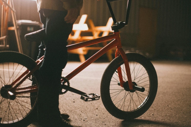 a person standing next to a bike in a garage, pexels contest winner, at a skate park, warm coloured, profile image, warm glow