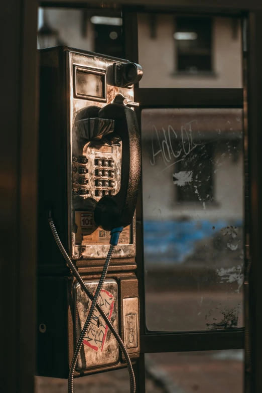 an old pay phone sitting on the side of a building, a photo, pexels contest winner, softly - lit, cracked, headset, instagram post