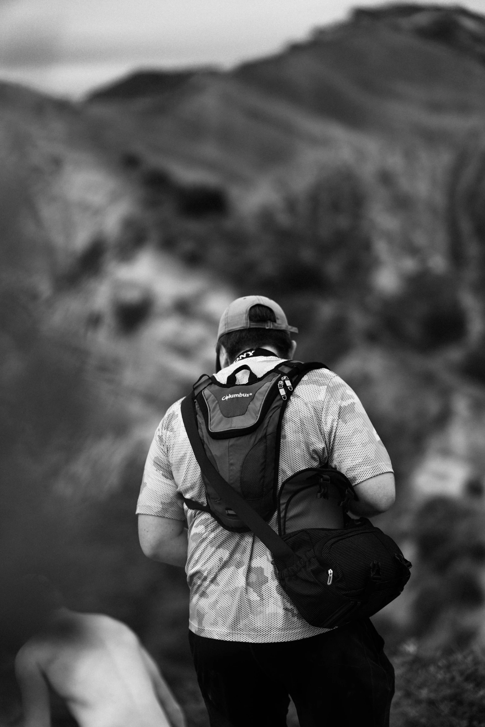 a black and white photo of a man with a backpack, by Altichiero, cinematic view!!!, in the hillside, hyperdetailed!!!, explore