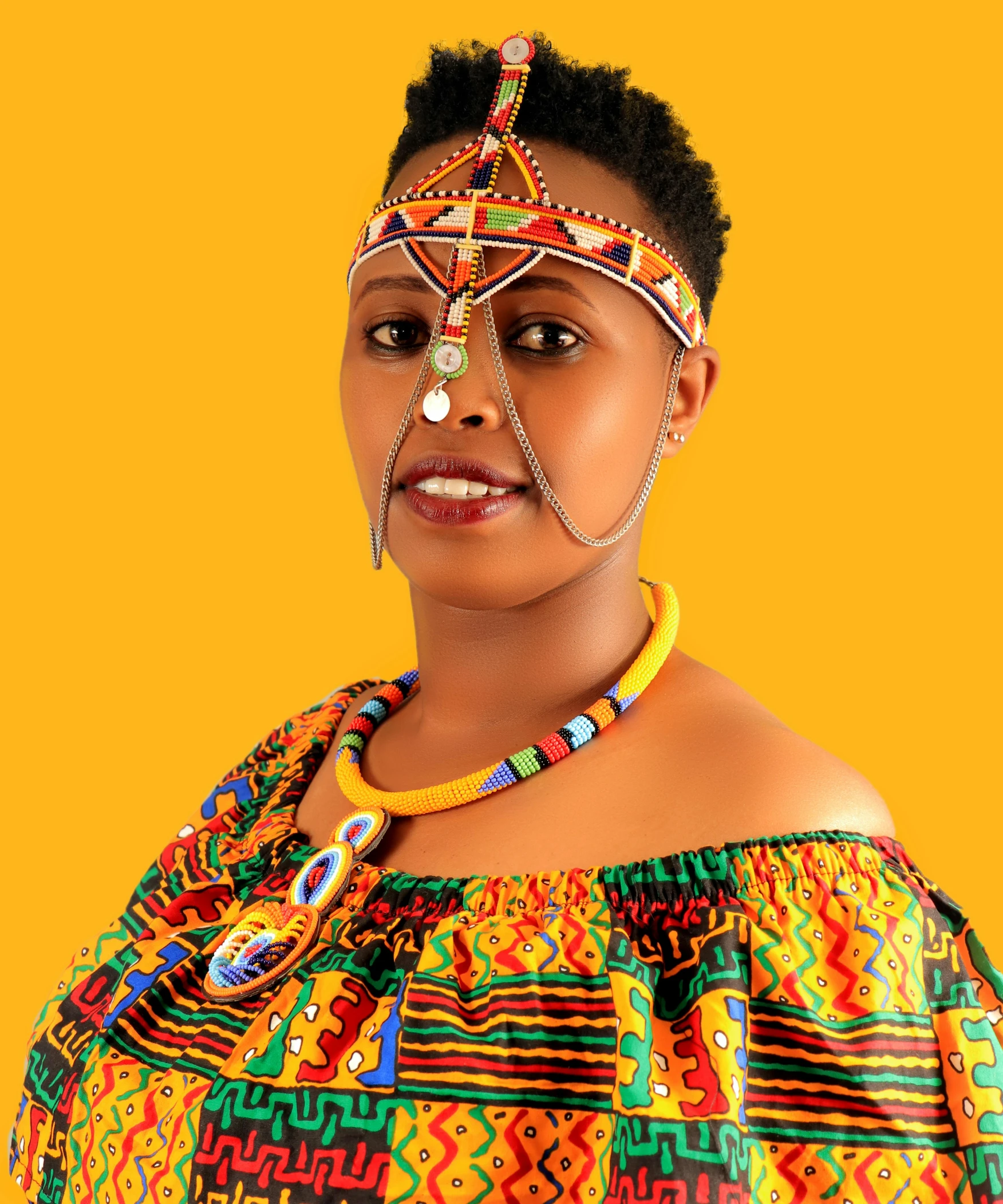 a woman in a colorful dress posing for a picture, an album cover, by Ingrida Kadaka, pexels contest winner, white and orange breastplate, mongezi ncaphayi, forehead jewelry, lgbtq