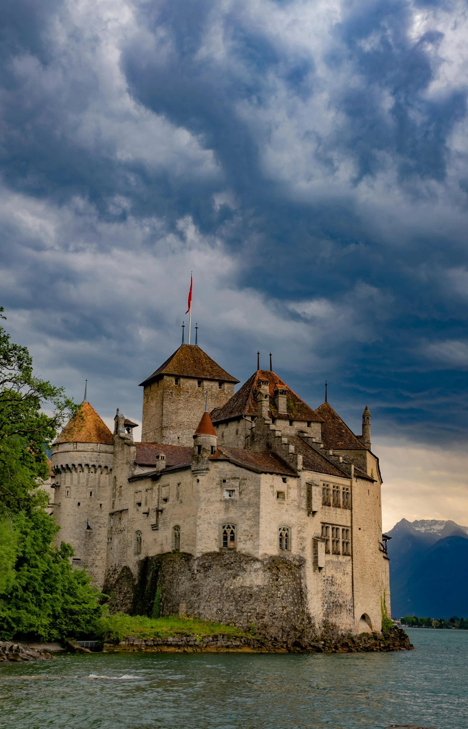 a castle sitting on top of a lake under a cloudy sky, an album cover, by Sven Erixson, pexels contest winner, renaissance, swiss modernizm, late afternoon light, turrets, alp