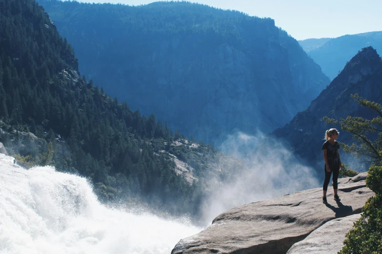 a man standing on top of a cliff next to a waterfall, by Ryan Pancoast, pexels contest winner, yosemite, website banner, rushing water, 2 5 6 x 2 5 6 pixels