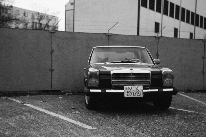 a black and white photo of a car in a parking lot, by Michalis Oikonomou, vintage - w 1 0 2 4, mercedez benz, ! low contrast!, michal mraz