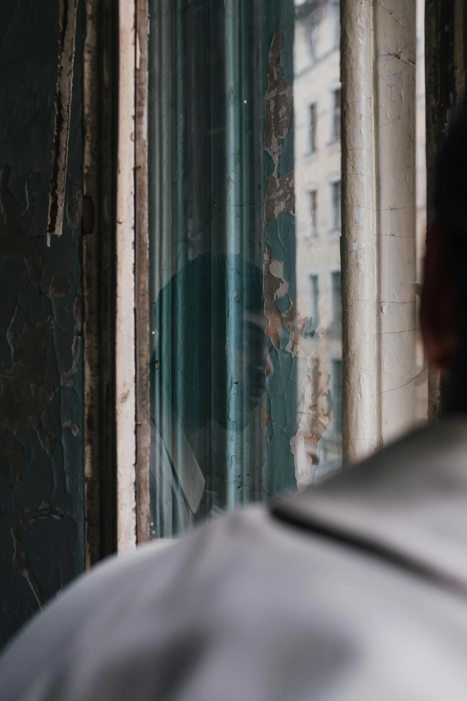 a man that is standing in front of a window, inspired by Elsa Bleda, unsplash, faded chipped paint, soviet apartment, close - up profile, ( ( theatrical ) )