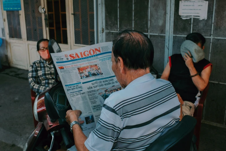 a man sitting on a bench reading a newspaper, a picture, by Sam Dillemans, pexels contest winner, vietnamese woman, parents watching, two old people, 15081959 21121991 01012000 4k