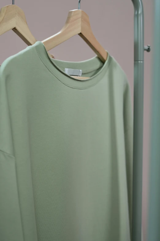 a green shirt hanging on a clothes rack, light green mist, detailed product image, extra close-up, round-cropped