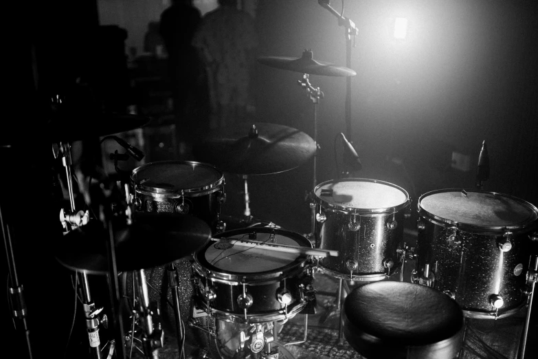 a black and white photo of a drum set, by Tom Bonson, pexels, shiny lighting, band playing instruments, corners, uploaded