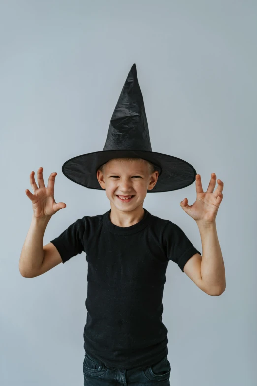 a young boy wearing a black witch hat, pexels contest winner, on a gray background, wearing a black tshirt, delightful, 15081959 21121991 01012000 4k