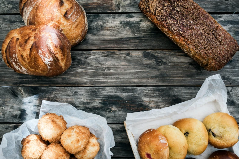 a variety of breads and pastries on a wooden table, by Niko Henrichon, unsplash, renaissance, square, background image, grain”