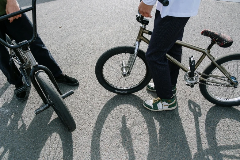 a man standing next to a woman on a bike, skate park, sense of scale, close up shot from the top, schools