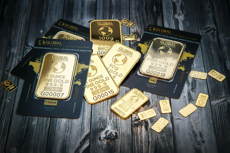 a pile of gold bars sitting on top of a wooden table, by Julia Pishtar, pexels contest winner, art nouveau, gold and black blu, mini model, bags of money, award winning advertising