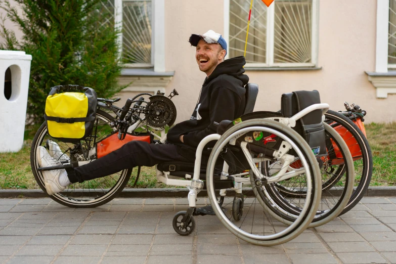 a man sitting in a wheel chair next to a bike, daniil kudriavtsev, avatar image, cheerful, profile image