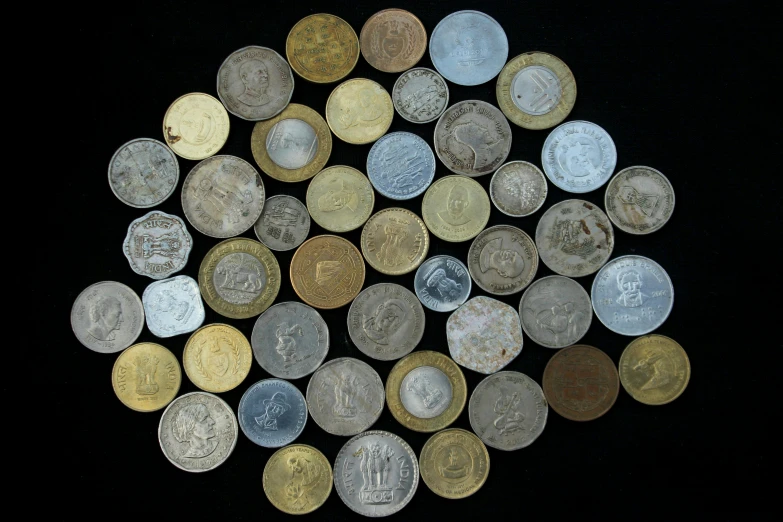 a pile of coins sitting on top of a black surface, a pastel, arte povera, mid - 3 0 s aged, | 28mm |, group photo, colombian