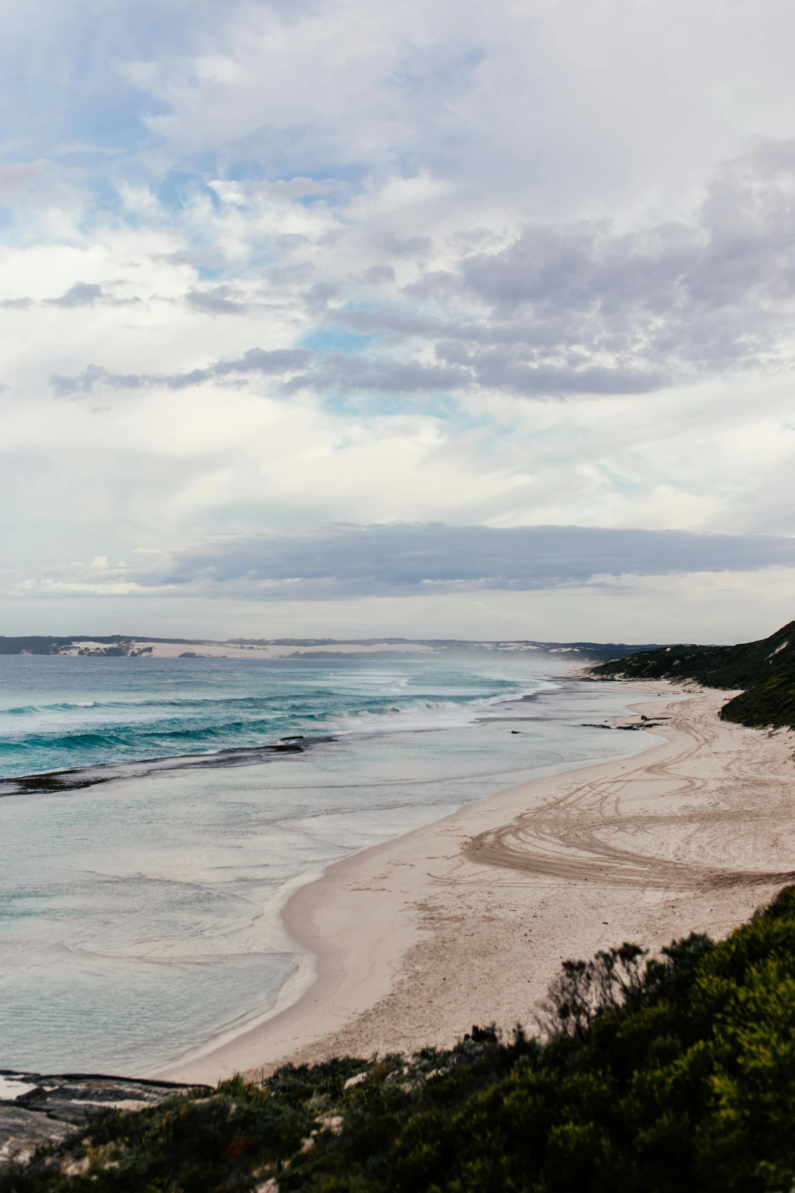 a view of a beach from the top of a hill, “ iron bark, clouds around, very elegant & complex, zac retz