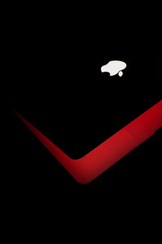 a close up of a laptop computer on a black background, by Adam Chmielowski, minimalism, curved red arrow, apple logo, black steel with red trim, lv