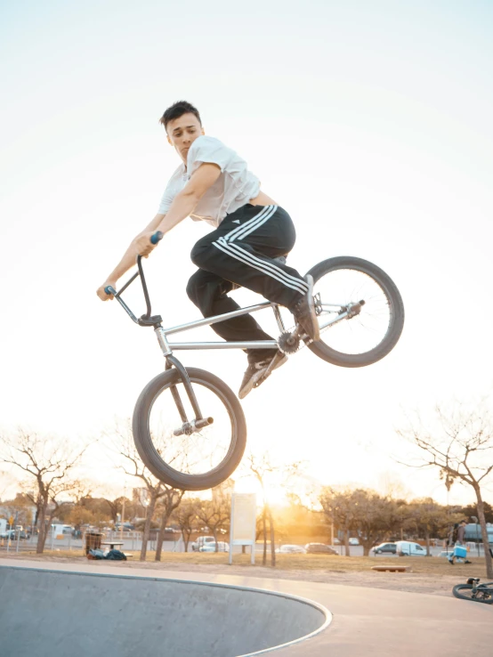 a man flying through the air while riding a bike, inspired by Seb McKinnon, pexels contest winner, realism, non-binary, large friendly eyes, college, doing a majestic pose