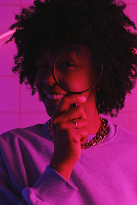 a woman holding a magnifying glass in front of her face, inspired by Carrie Mae Weems, trending on pexels, afrofuturism, neon purple, looking happy, lo fi colors, curls and curves