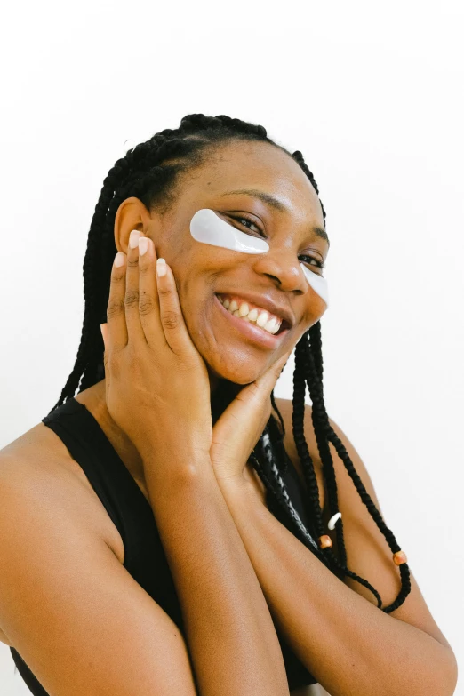 a woman with eye patches on her face, trending on pexels, afrofuturism, clean face and body skin, looking happy, essence, left eye stripe