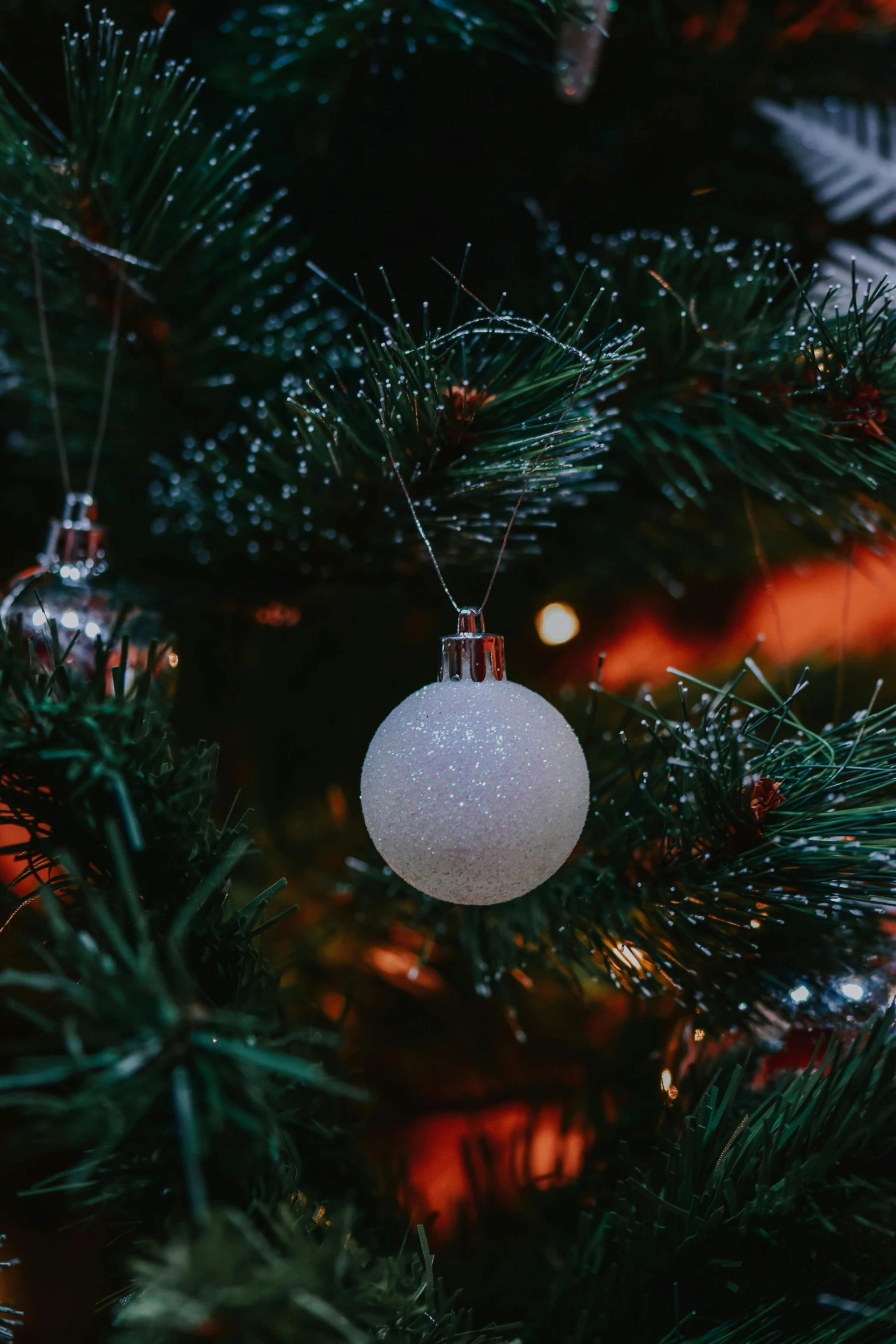 a close up of a christmas tree with ornaments, a portrait, by Adam Marczyński, pexels, glowing white accent lighting, hanging out with orbs, ilustration, paul barson