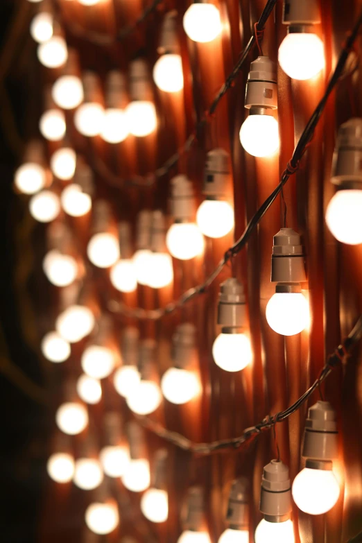 a bunch of lights hanging from the side of a building, light bulbs, orange lights, subtle detailing, white lighting