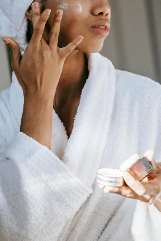 a woman in a bathrobe talking on a cell phone, trending on pexels, renaissance, synthetic bio skin, cream, manuka, white and pink cloth