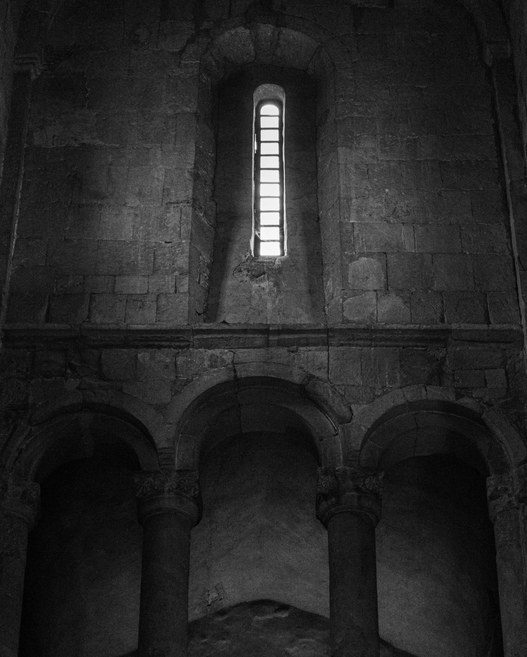 a black and white photo of a window in a building, by Jan Kupecký, unsplash contest winner, romanesque, dark scene with dim light, in a sanctuary, triptych, album cover