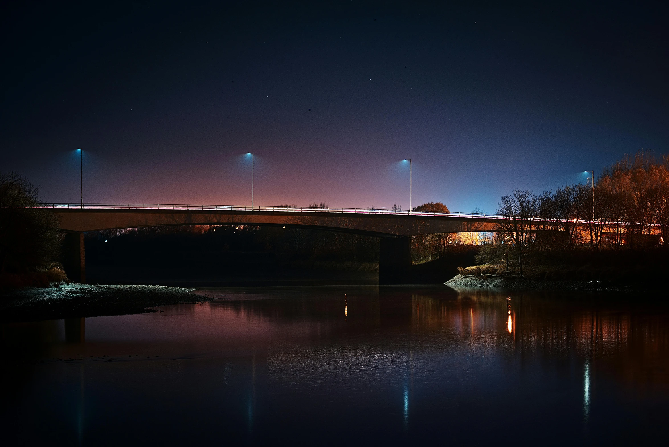 a bridge over a body of water at night, by Eglon van der Neer, pexels contest winner, medium format. soft light, paul barson, streetlight at night, 2022 photograph