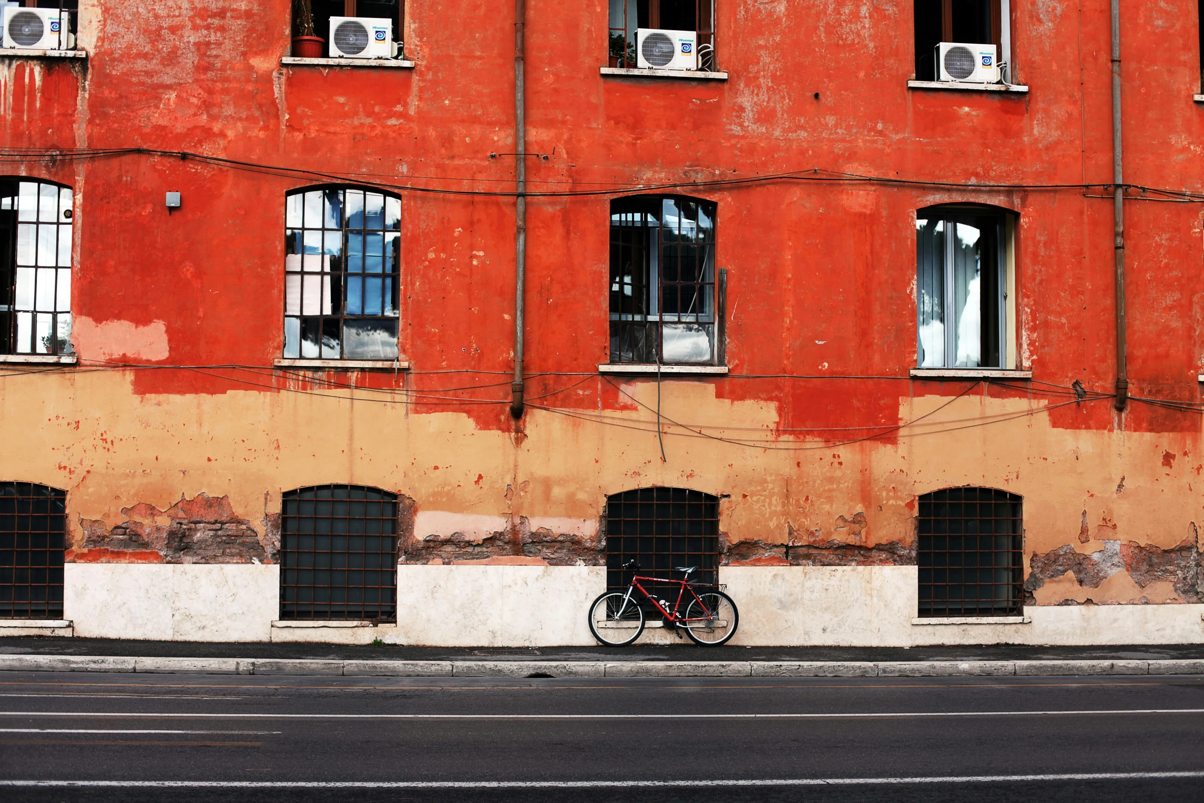 a bike is parked in front of a building, inspired by Steve McCurry, pexels contest winner, postminimalism, burnt sienna and venetian red, view from across the street, freddy mamani silvestre facade, a small