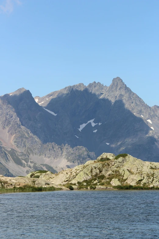 a body of water with mountains in the background, a picture, les nabis, high elevation, craggy, seen from outside, pyranees